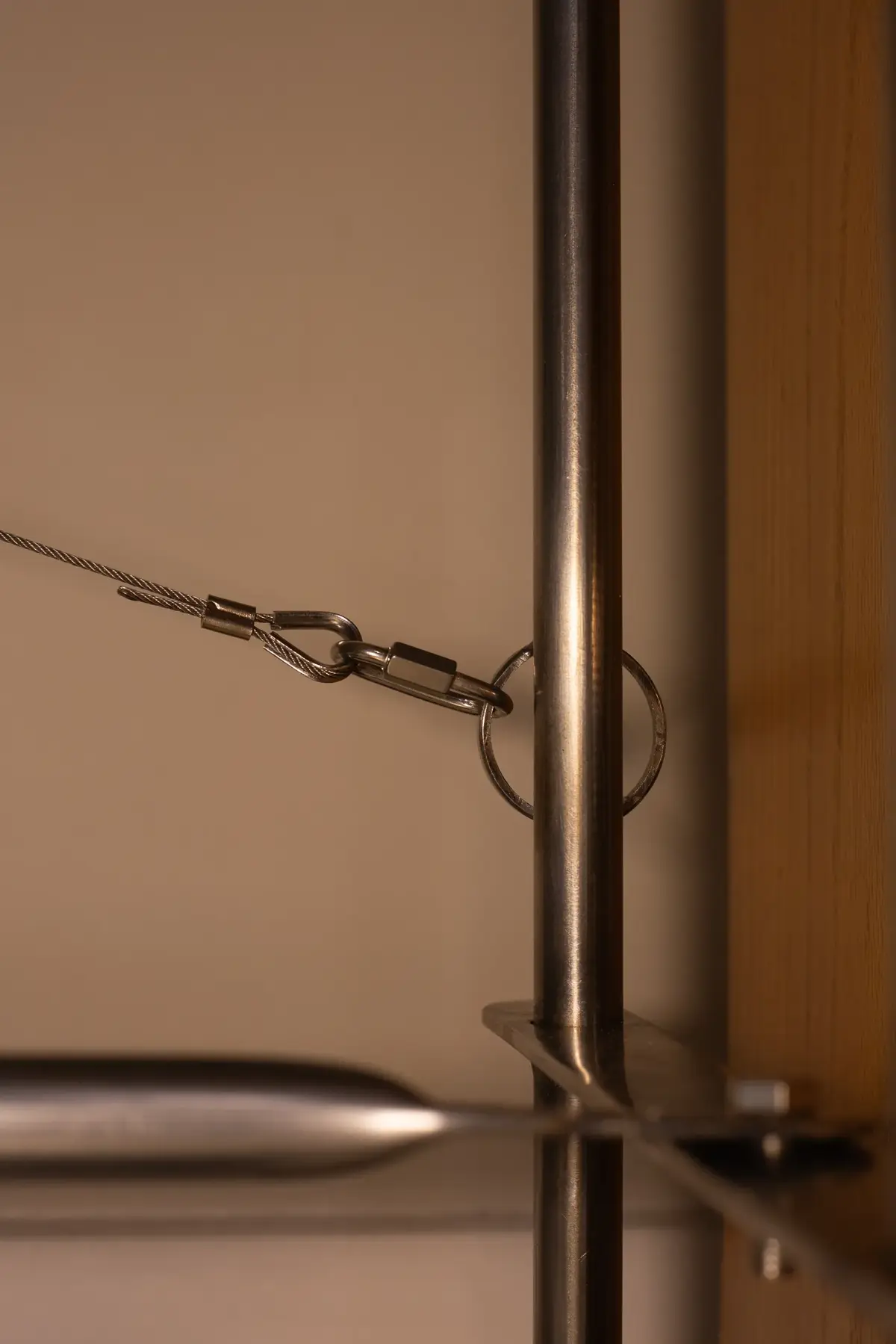 Close-up view of a metal rod with a chain and hook attachment point.