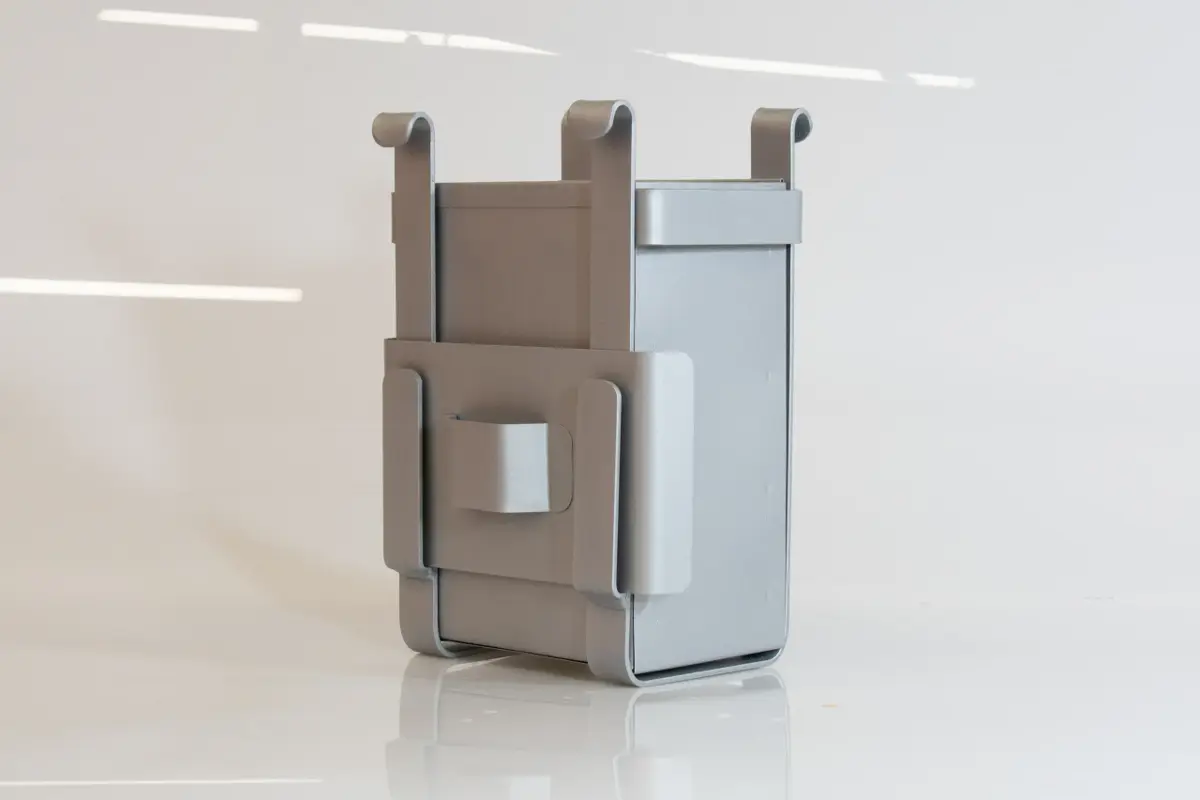 A fabricated metal prototype for a composting bin, shown in a clean, studio setting.