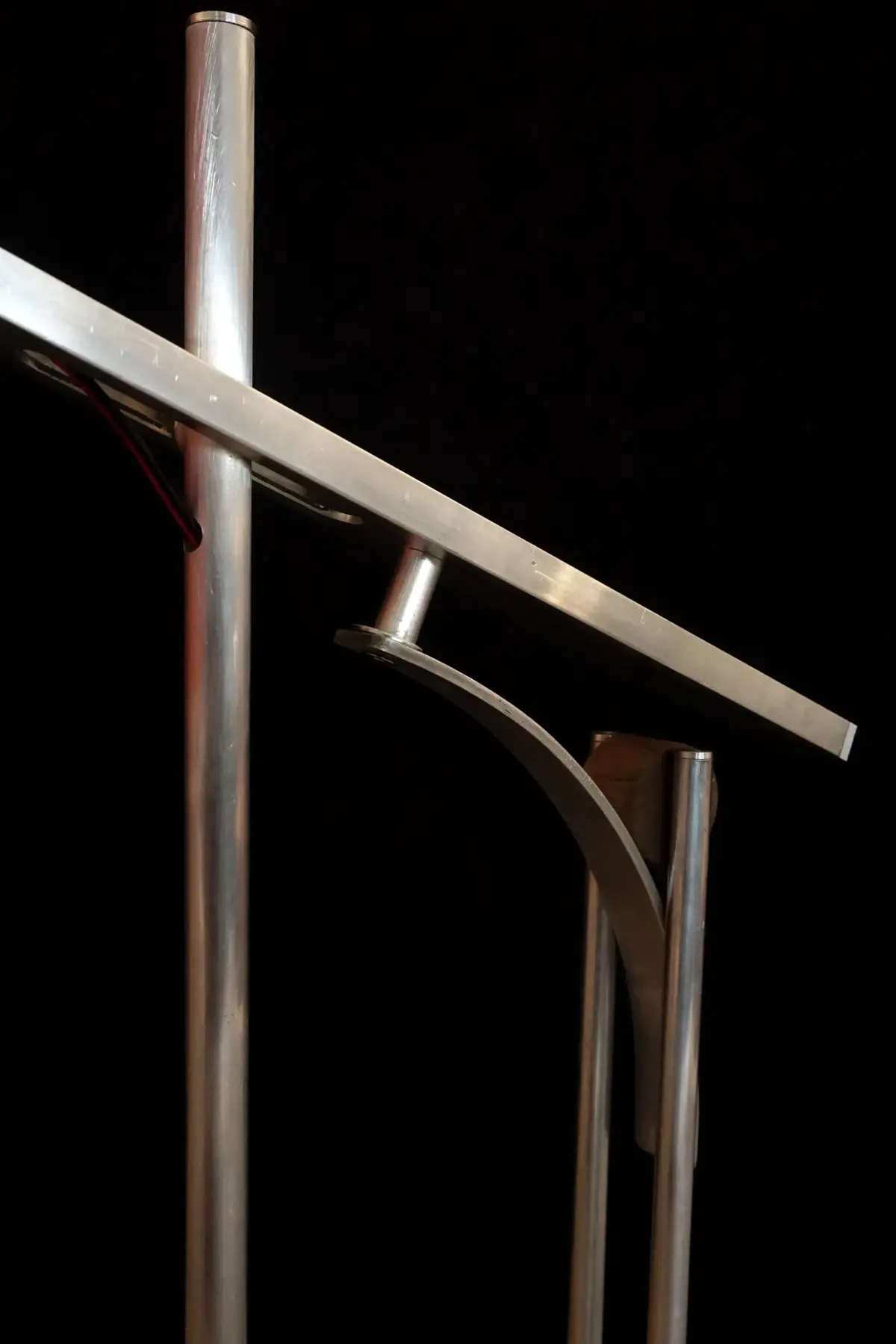 Close-up view of the metal frame and horizontal arm of the 'Tei' lamp design.