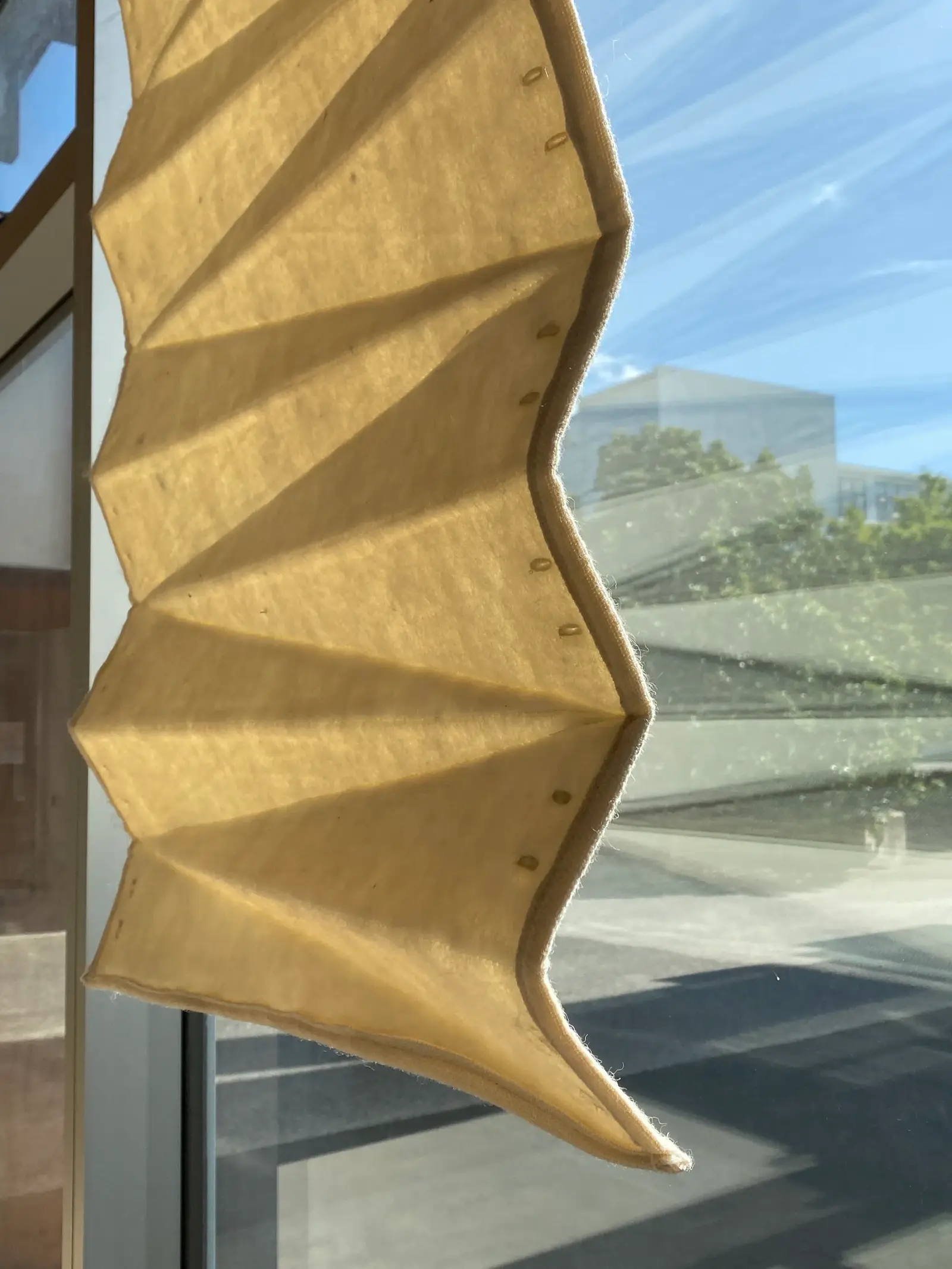A curved, stitched textile prototype piece shown in natural light, exploring contour design.
