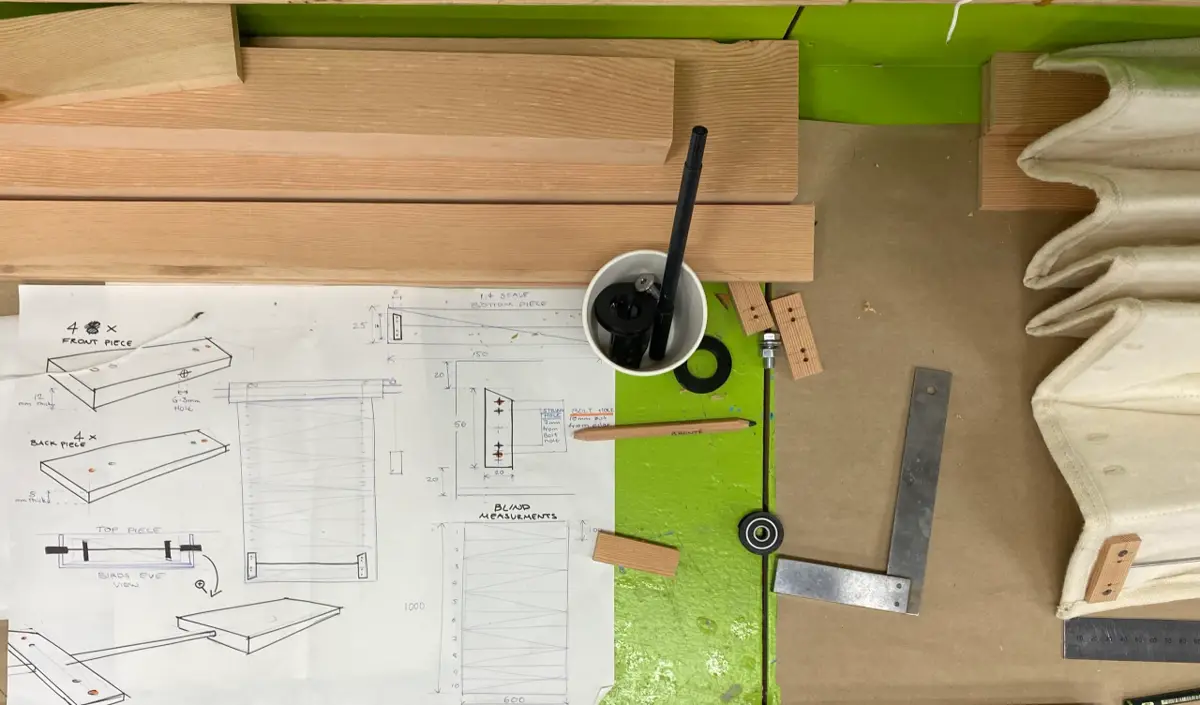 A flat lay view of wood measurements, textile samples, and design sketches for the Contour project.