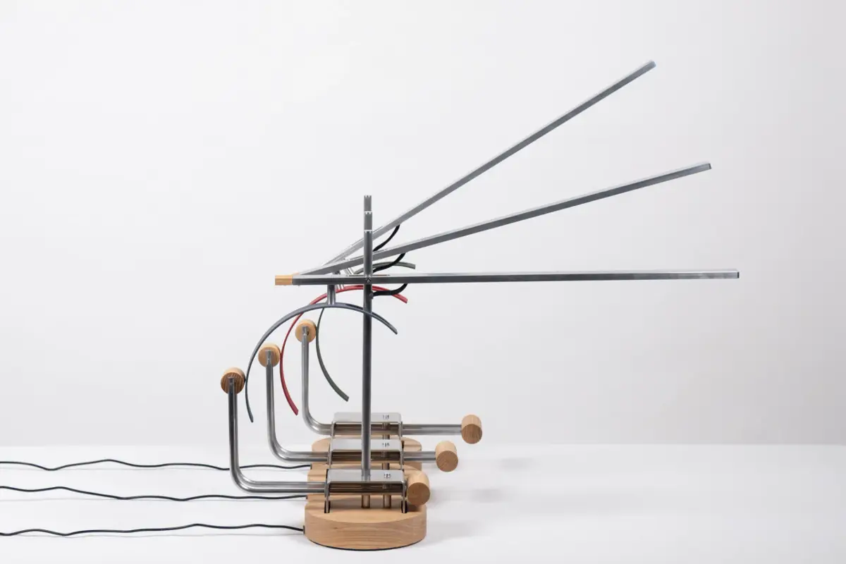 The finished metal and wood lamp, 'Tei', is displayed on a white surface.
