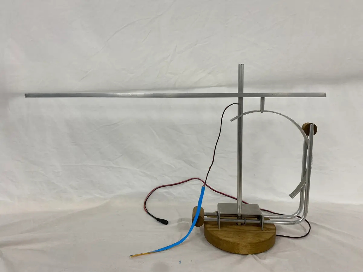A metal and wood prototype of the Tei lamp shown on a white background.